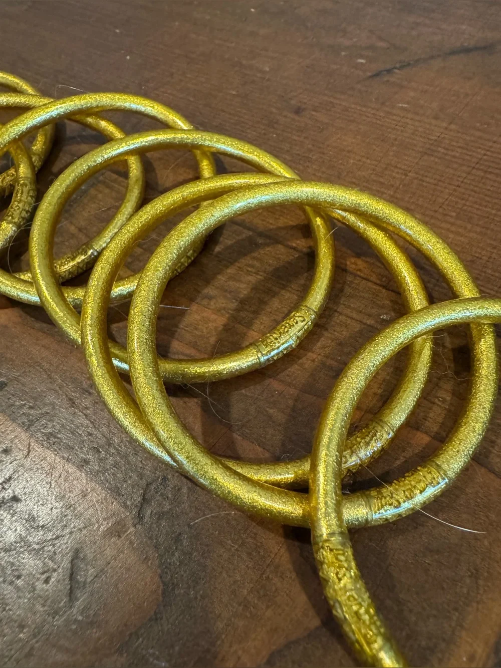 Set of 9 gold plastic glitter bracelets